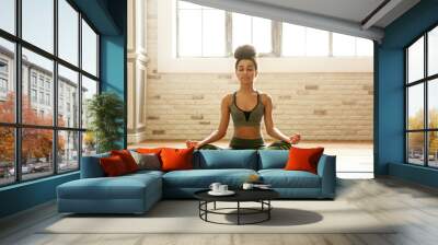 Sporty African-American woman practicing yoga indoors Wall mural