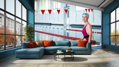 Sporty female swimmer in pool Wall mural