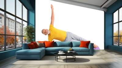 Sporty mature man doing yoga on mat against white background Wall mural