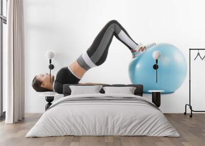 Sporty young Asian woman exercising with fitball on white background Wall mural