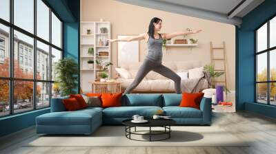 Sporty young pregnant woman training at home Wall mural