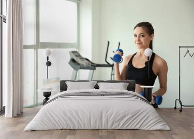 Sporty young woman training in gym Wall mural