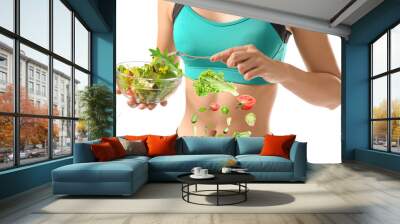 Sporty young woman with healthy vegetable salad on white background. Concept of diet Wall mural