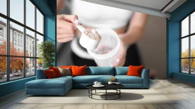 Sporty young woman with protein at home, closeup Wall mural