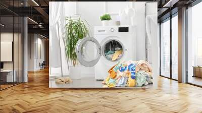 Stack of dirty clothes and washing machine in laundry room Wall mural