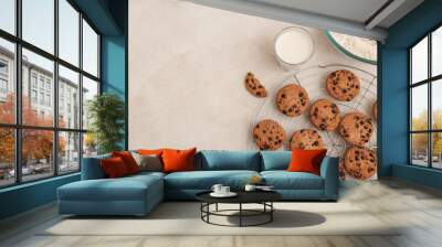 Stand of sweet cookies with chocolate chips and glass of milk on white background Wall mural