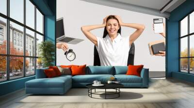 Stressed young secretary with a lot of work at table on white background Wall mural