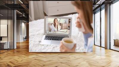 Stressed young woman asking psychologist for advice online at home Wall mural