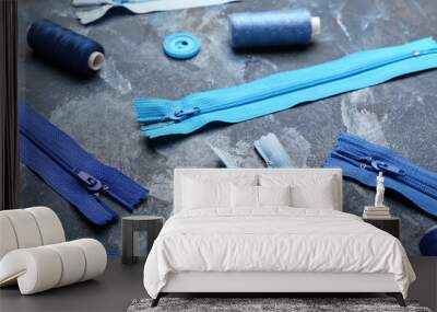 Stylish blue zippers, threads and buttons on blue grunge background Wall mural