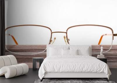 Stylish eyeglasses on wooden table against white background Wall mural