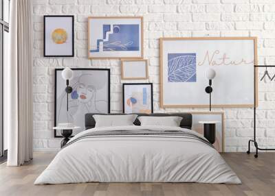 Stylish pictures hanging on brick wall Wall mural