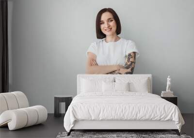 Stylish tattooed woman on light background Wall mural