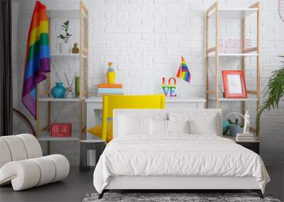 Stylish workplace with rainbow flags near white brick wall Wall mural