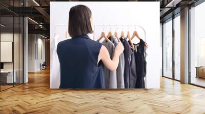 Stylish young woman choosing clothes in her dressing room at home Wall mural