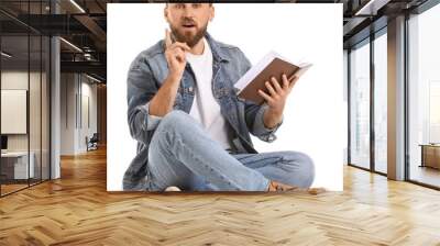 Surprised young man reading book on white background Wall mural