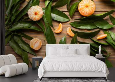 Sweet mandarins and leaves on wooden background Wall mural