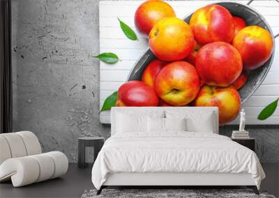 Sweet ripe nectarines in basket on grey background Wall mural