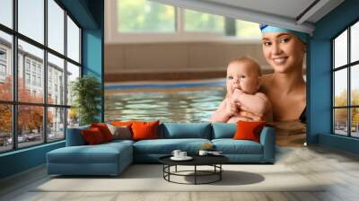 Swimming coach and adorable little baby in pool Wall mural