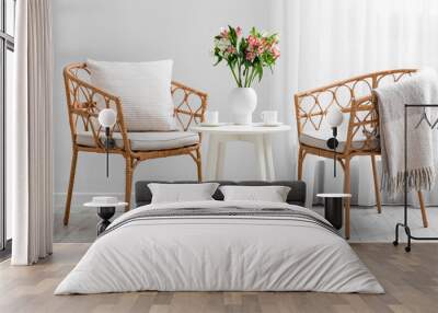 Table with beautiful alstroemeria flowers, cups of coffee and chairs in interior of living room Wall mural