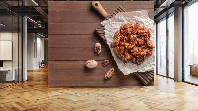 Tasty candied pecan nuts on wooden table Wall mural