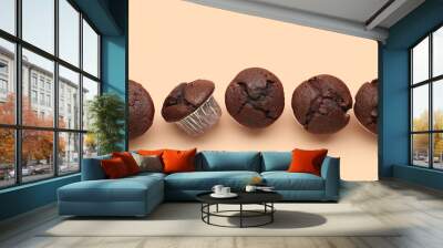 Tasty chocolate cupcakes on beige background Wall mural