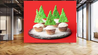 Tasty Christmas cupcakes on red background Wall mural