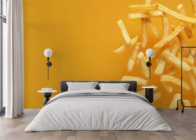 Tasty french fries on orange background Wall mural