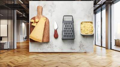 Tasty Parmesan cheese with grater, knife and board on grey background Wall mural