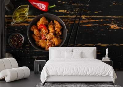 Tasty sweet and sour chicken in bowl with spices on dark wooden background Wall mural