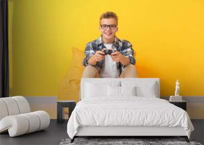 Teenage boy playing video game near color wall Wall mural