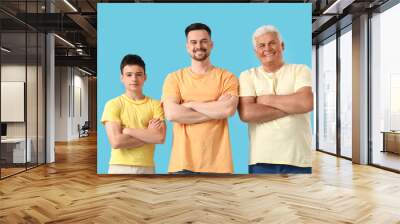 Teenage boy with his dad and grandfather on blue background Wall mural