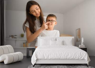 teenage girl touching nose of her little brother in kitchen Wall mural