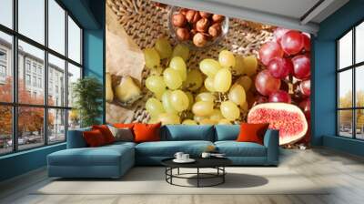 Tray with sweet grapes, fig, honey and hazelnuts on plaid, closeup Wall mural