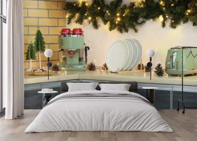 Utensils on counter with Christmas lights and fir branches in kitchen Wall mural