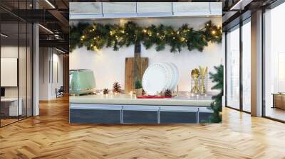 Utensils on counter with Christmas lights and fir branches in kitchen Wall mural