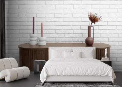 Vase with dried red protea and candles on dresser near white brick wall Wall mural