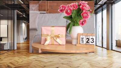 Vase with flowers, gift box and calendar on coffee table in living room Wall mural