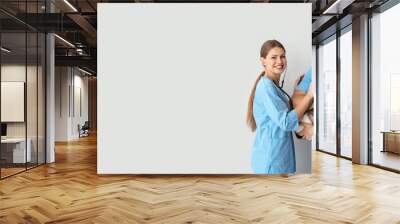 Veterinarians and cute dog on light background with space for text Wall mural