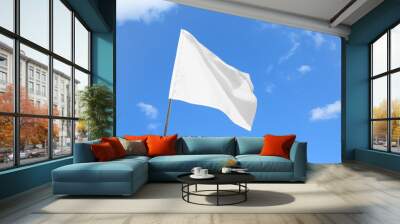 Waving white flag against blue sky Wall mural