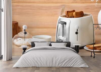 White toaster with bread slices and cup of coffee on table near wooden wall Wall mural