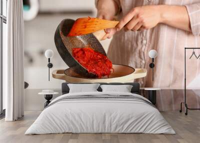 Woman adding frying beet to cooking pot, closeup Wall mural