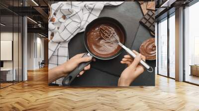 Woman cooking tasty melted chocolate on table in kitchen Wall mural