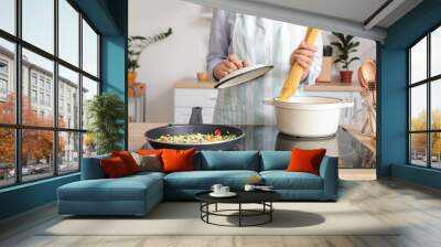 Woman cooking tasty pasta on kitchen stove, closeup Wall mural