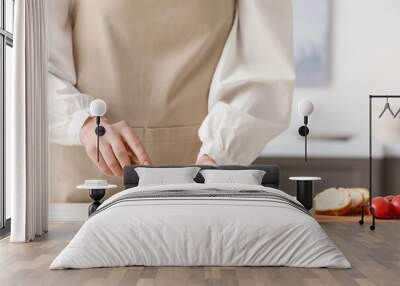 Woman cutting delicious feta cheese on table Wall mural