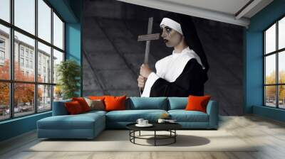 Woman dressed for Halloween as nun on dark background Wall mural