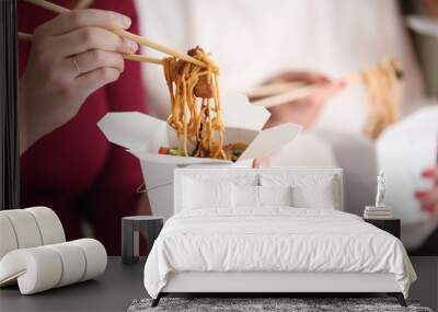 Woman eating chinese noodles from takeaway box, closeup Wall mural