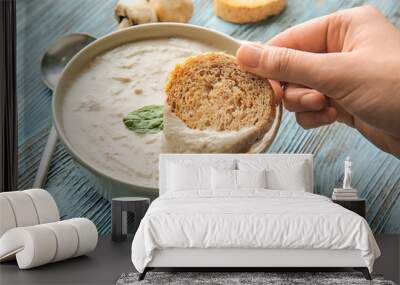 Woman eating delicious mushroom cream soup with bread, closeup Wall mural