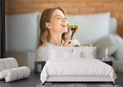 Woman eating healthy vegetable salad in office Wall mural