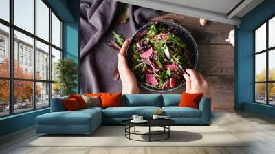 Woman eating tasty couscous with vegetables on wooden background Wall mural