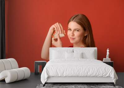 Woman eating tasty taco on color background Wall mural